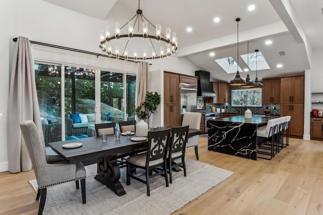 dining space featuring lofted ceiling with skylight, light wood-style flooring, a notable chandelier, and visible vents