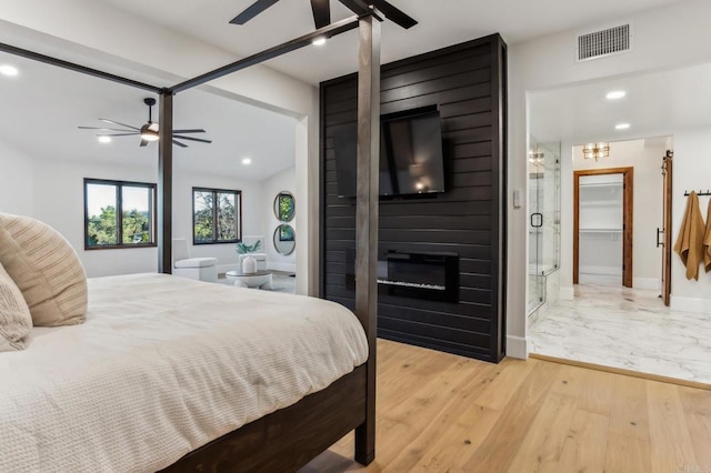 bedroom with visible vents, light wood-style flooring, recessed lighting, a fireplace, and baseboards