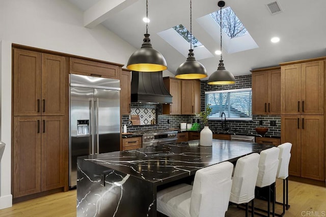 1326 Farmer Rd, Julian, CA 92036 - kitchen featuring custom range hood, dark countertops, beam ceiling, a skylight, and premium appliances