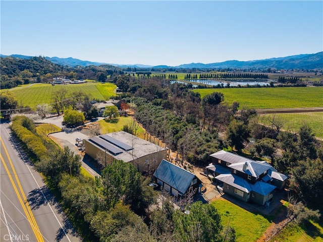 birds eye view of property featuring a water and mountain view and a rural view