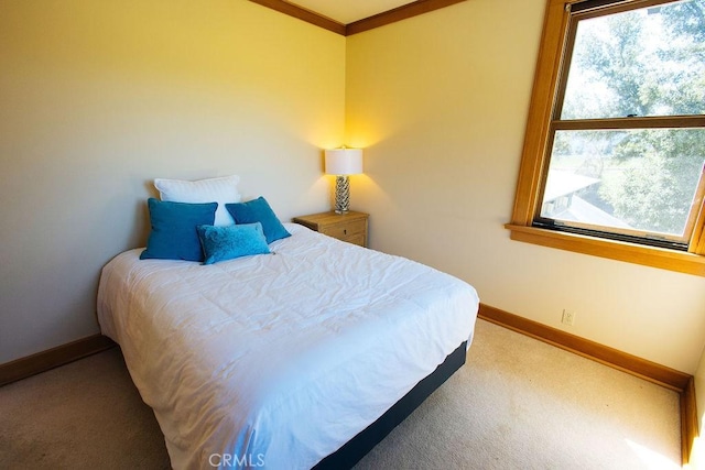 carpeted bedroom with crown molding and baseboards