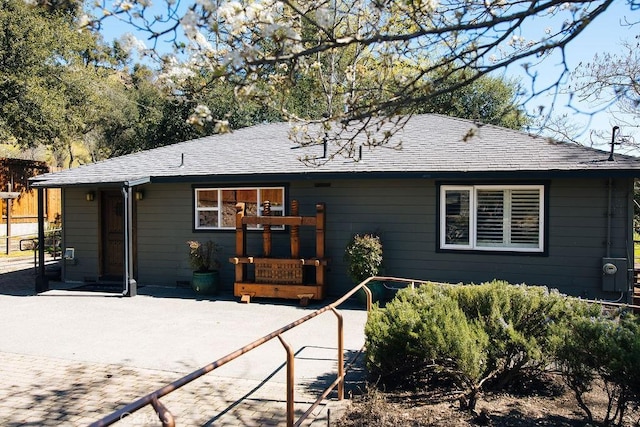 back of house with roof with shingles