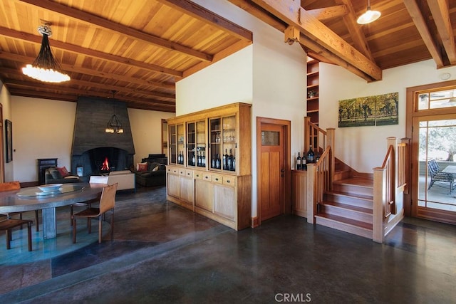 kitchen with beam ceiling, wooden ceiling, a fireplace, and concrete floors