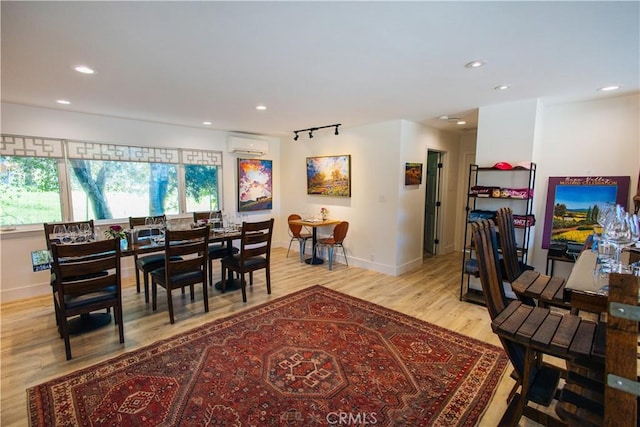 dining space with recessed lighting, light wood-style floors, baseboards, and a wall mounted air conditioner