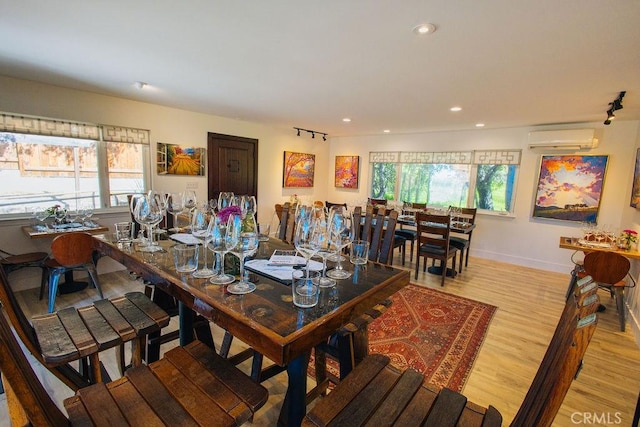 dining space with plenty of natural light, recessed lighting, an AC wall unit, and light wood-type flooring