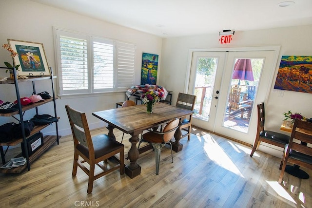 dining area with french doors, light wood-type flooring, and baseboards