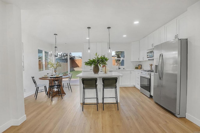 kitchen featuring white cabinets, stainless steel appliances, light countertops, and light wood-style floors