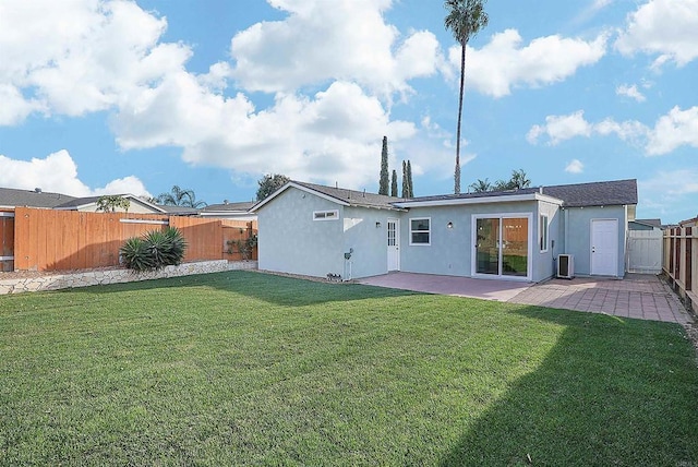 rear view of property with central air condition unit, stucco siding, a lawn, a patio, and a fenced backyard