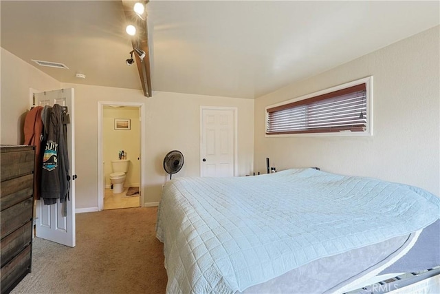 bedroom featuring visible vents, baseboards, carpet, and ensuite bath