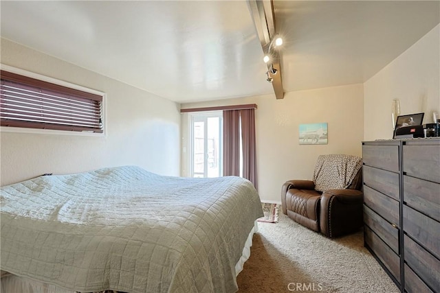 bedroom featuring beam ceiling, rail lighting, and carpet