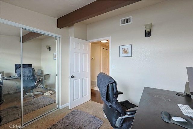 carpeted home office with beamed ceiling, baseboards, and visible vents