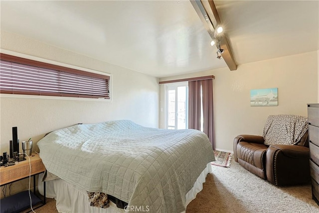 bedroom featuring beamed ceiling, carpet flooring, and rail lighting