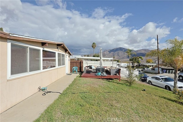 view of yard featuring fence, a mountain view, and an outdoor hangout area