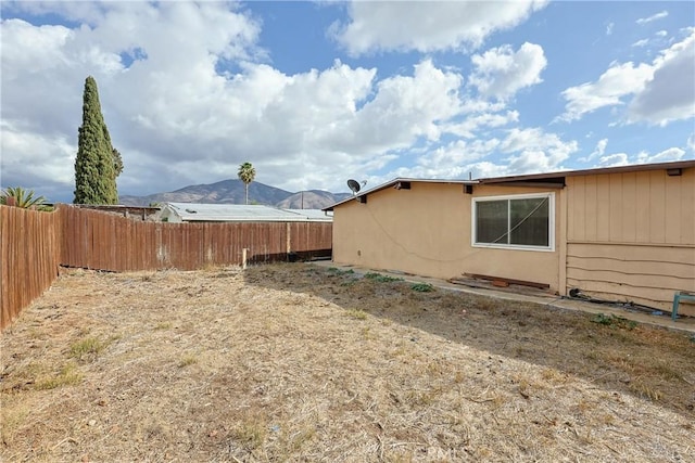 view of yard with a mountain view and fence