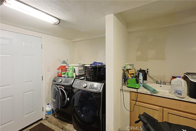 laundry room featuring laundry area, washer and dryer, a textured ceiling, and a sink