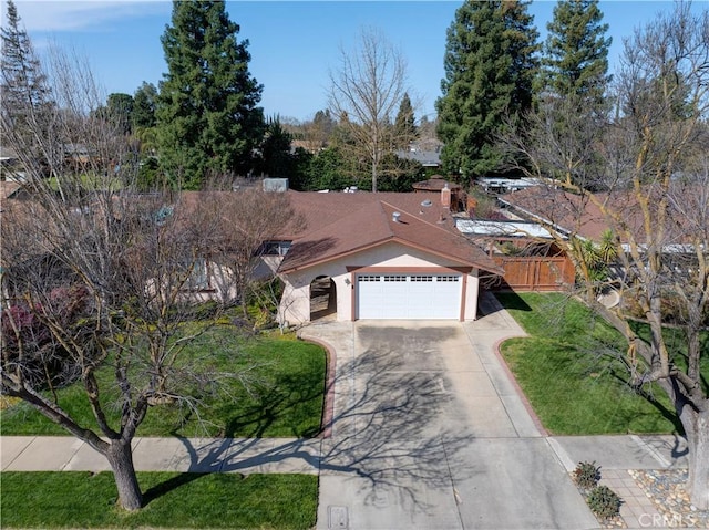 view of front facade featuring concrete driveway, a front yard, and stucco siding