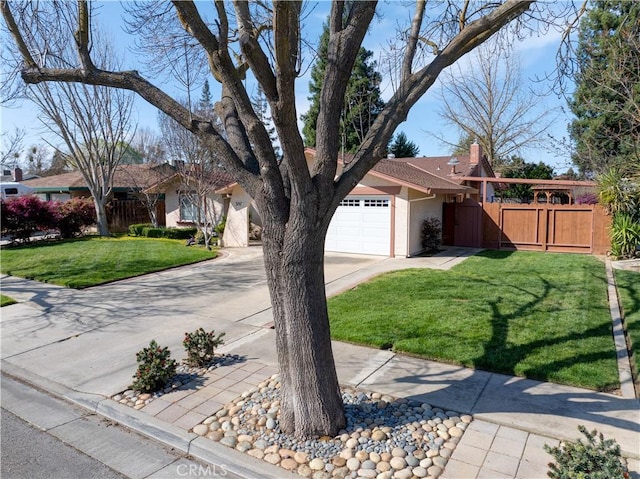 ranch-style home with concrete driveway, an attached garage, fence, and a front lawn