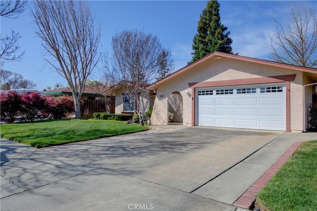 ranch-style home featuring a front lawn, an attached garage, driveway, and stucco siding