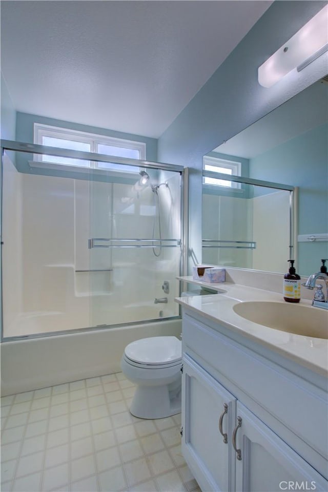 full bathroom featuring vanity, toilet, and shower / bath combination with glass door