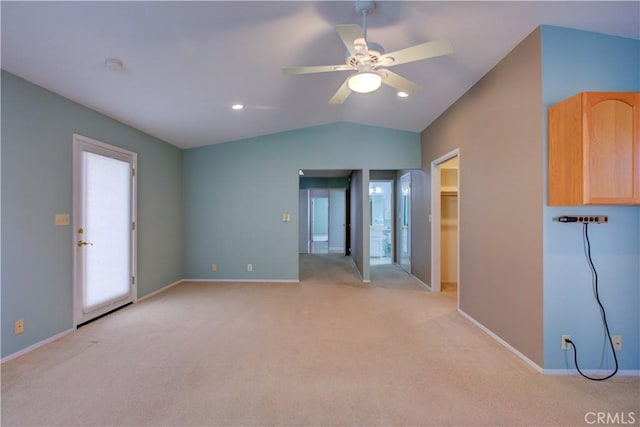 spare room with baseboards, lofted ceiling, light colored carpet, and a ceiling fan