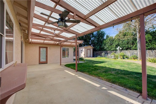 view of patio featuring a fenced backyard, a storage unit, an outdoor structure, and a pergola