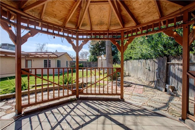 view of patio / terrace featuring a gazebo, an outdoor structure, a fenced backyard, and a storage shed