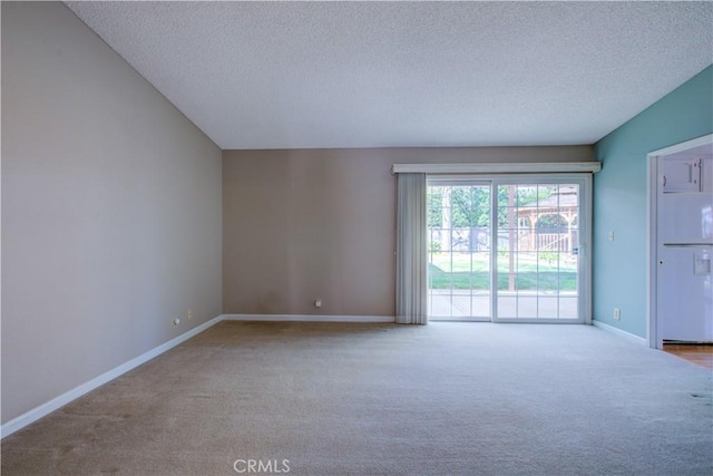 carpeted spare room featuring a textured ceiling and baseboards