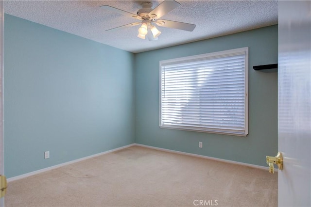 spare room featuring a textured ceiling, baseboards, carpet floors, and ceiling fan