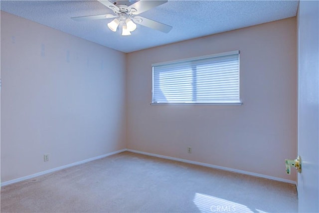 spare room featuring light carpet, baseboards, a textured ceiling, and ceiling fan