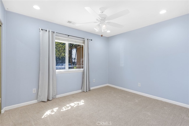 carpeted spare room with a ceiling fan, baseboards, and visible vents