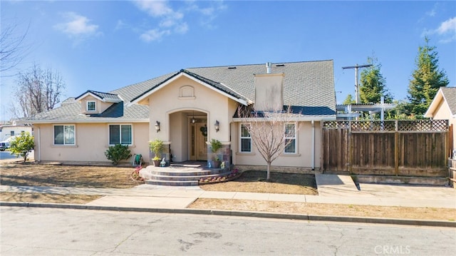 view of front of home featuring stucco siding and fence