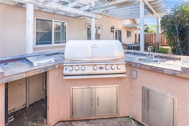 view of patio / terrace featuring fence, exterior kitchen, area for grilling, a pergola, and a sink