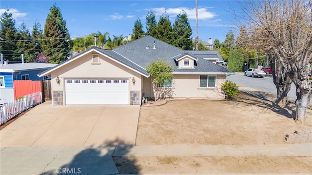 view of front of property with fence, concrete driveway, roof with shingles, stucco siding, and an attached garage