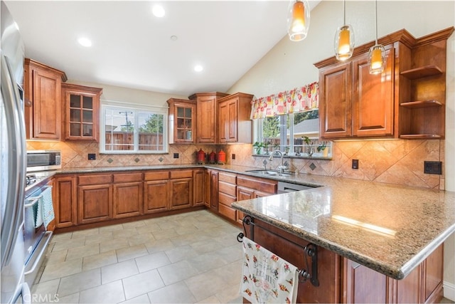 kitchen with pendant lighting, light stone counters, brown cabinets, a peninsula, and a sink