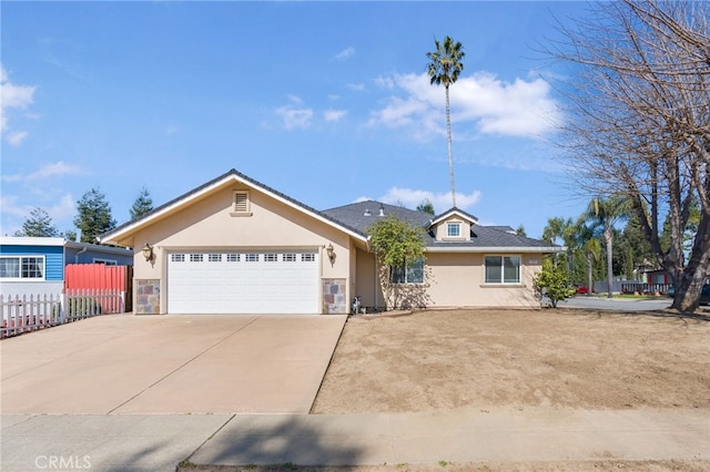 single story home with fence, stucco siding, concrete driveway, a garage, and stone siding