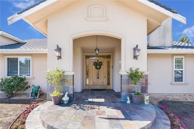 doorway to property featuring stucco siding