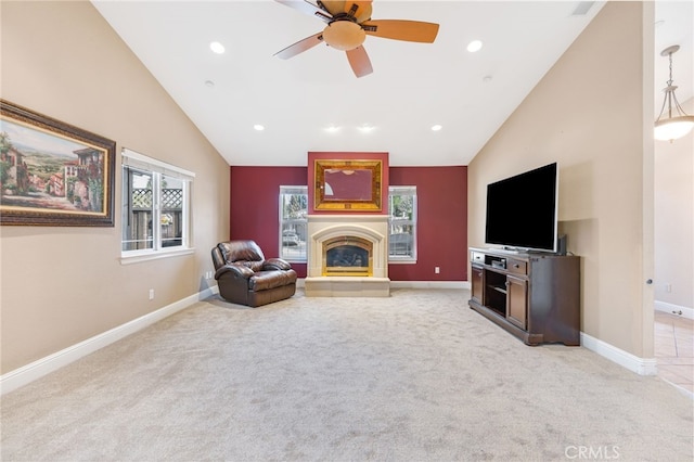 living room featuring high vaulted ceiling, a glass covered fireplace, baseboards, light colored carpet, and ceiling fan