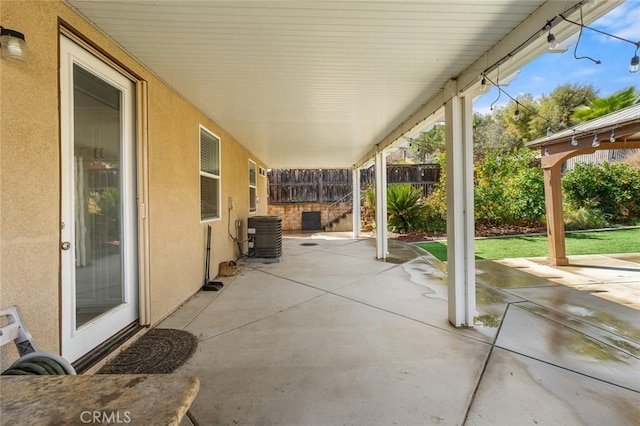 view of patio / terrace with central AC unit and fence