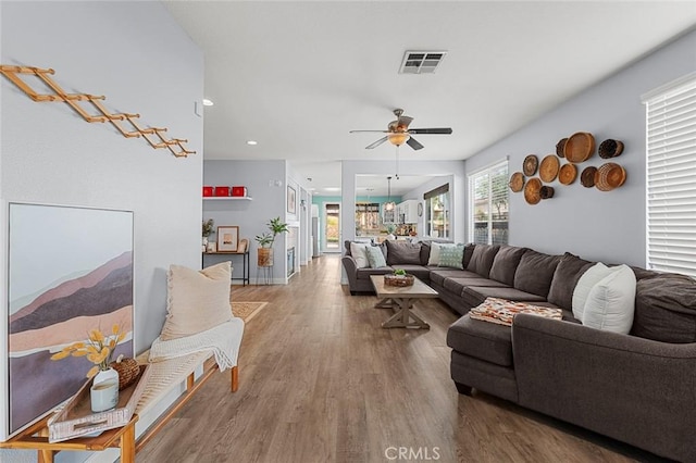 living room with visible vents, a ceiling fan, and wood finished floors