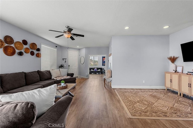 living area featuring a ceiling fan, recessed lighting, wood finished floors, and baseboards