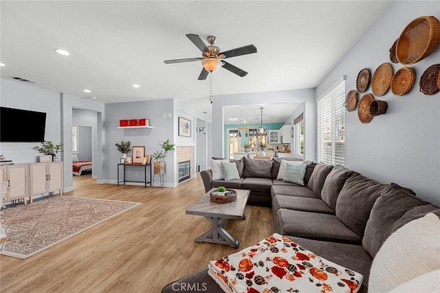 living area with baseboards, visible vents, light wood-style flooring, recessed lighting, and ceiling fan