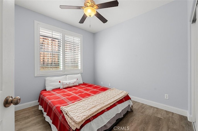 bedroom featuring a ceiling fan, baseboards, and wood finished floors