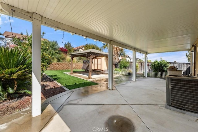 view of patio / terrace featuring a shed, central AC, an outdoor structure, and fence