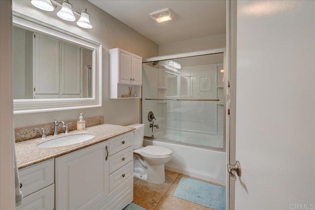 bathroom with vanity, tile patterned floors, toilet, and shower / bath combination with glass door