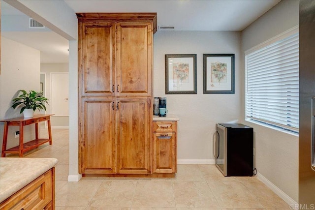 interior space featuring brown cabinetry, visible vents, light countertops, and light tile patterned floors