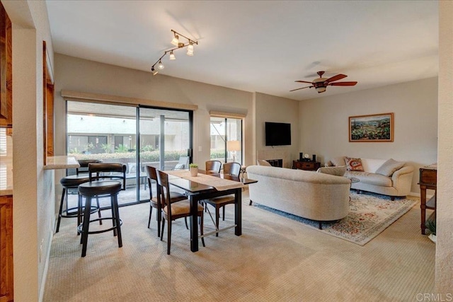 dining room featuring a ceiling fan and light colored carpet