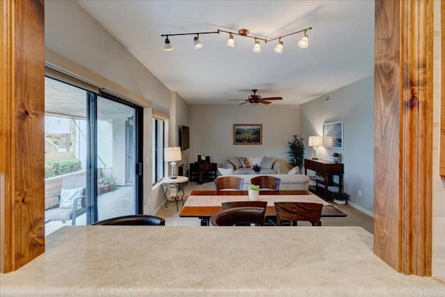 living area featuring track lighting, baseboards, and ceiling fan