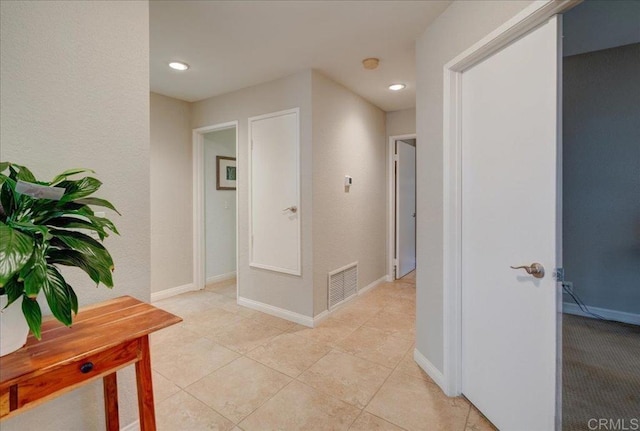 corridor with light tile patterned floors, visible vents, recessed lighting, and baseboards