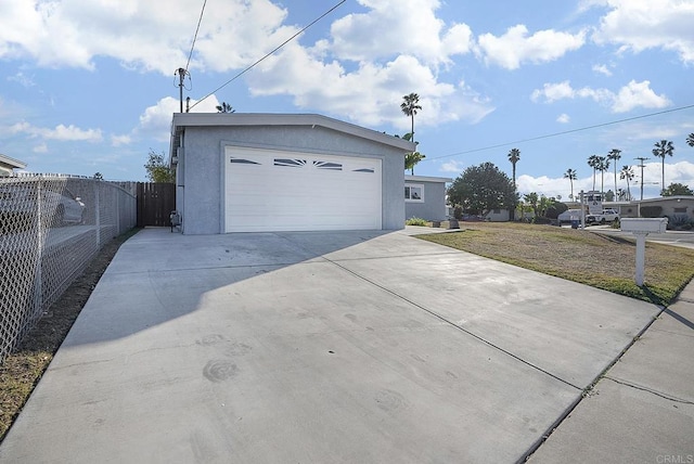 garage featuring fence and driveway