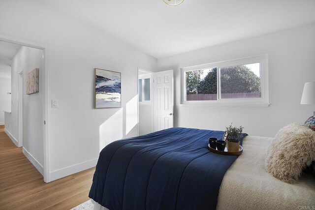 bedroom with light wood-style floors and baseboards